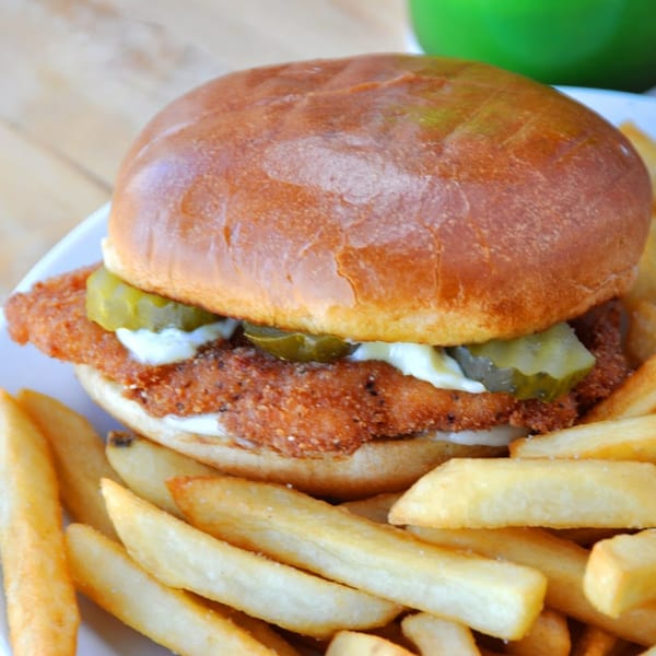 The Bird's fried chicken sandwich with pickles, mayonnaise, and a side of golden fries.